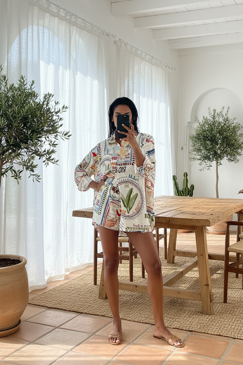 woman wearing a colorful patterned outfit taking a mirror selfie.