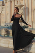 Woman in a black dress standing in front of a fountain