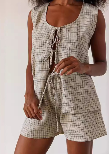 Person wearing a checkered romper with a white background