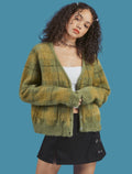 Woman wearing a green plaid cardigan on a blue background
