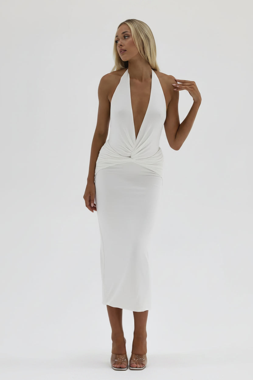 Woman wearing a white dress with a plunging neckline on a plain background