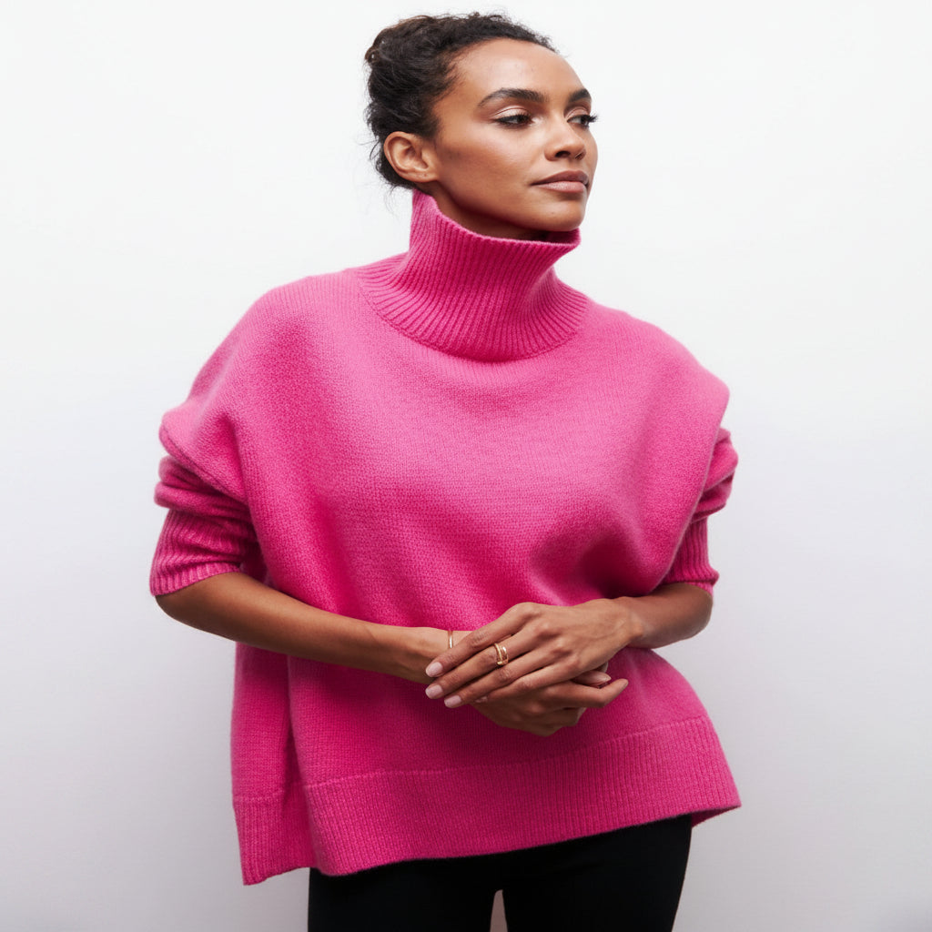 Woman wearing a bright pink turtleneck sweater against a plain background